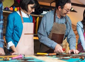 groupe de participants autour d'une table avec des outils et accessoires variés lors d'un atelier diy