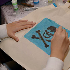 enfant participant à un atelier de personnalisation de sac lors d'un événement d'entreprise