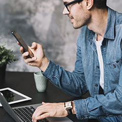 homme participant à un quiz en ligne sur smartphone et ordinateur en simultané